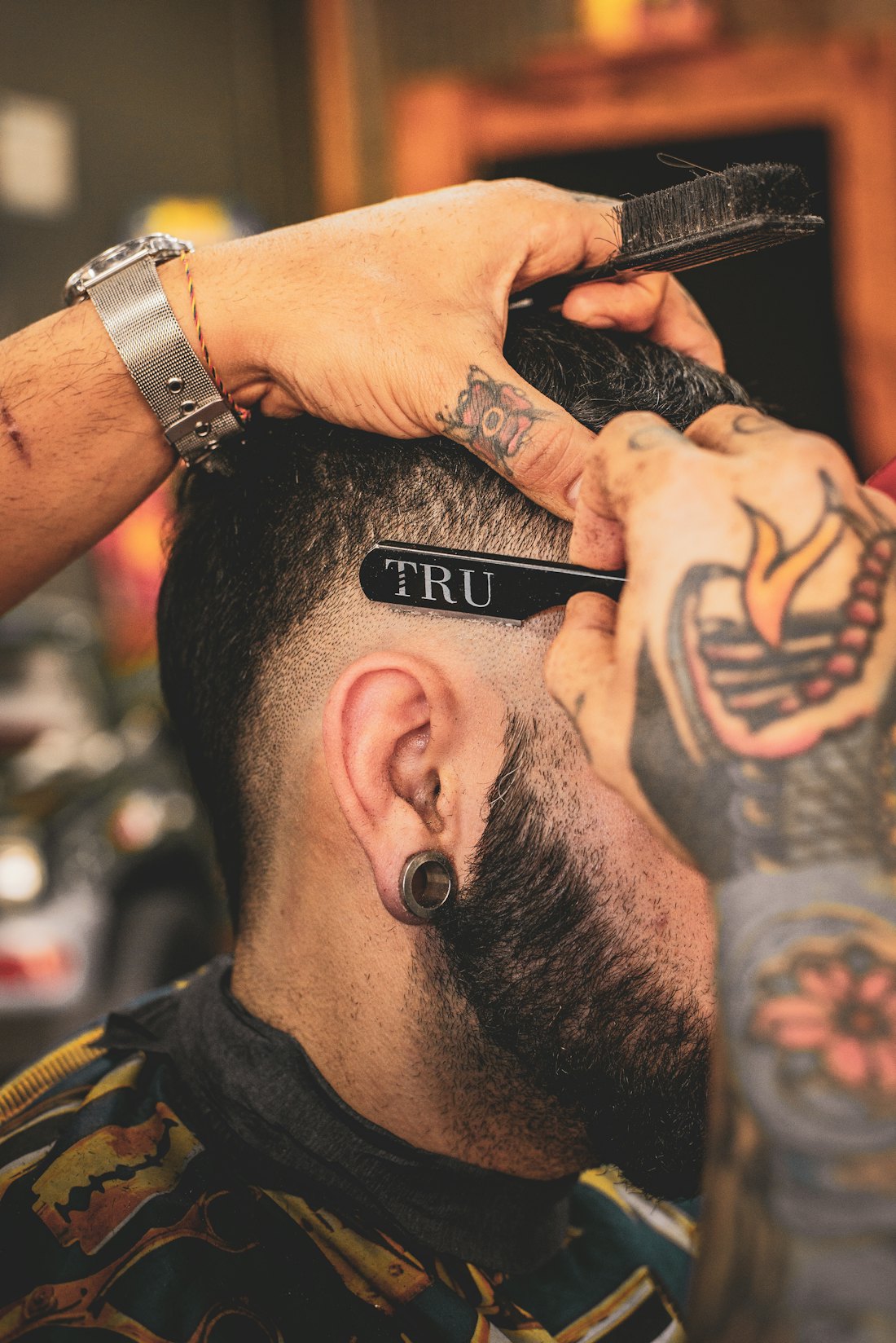 Barber cutting a design into a fade