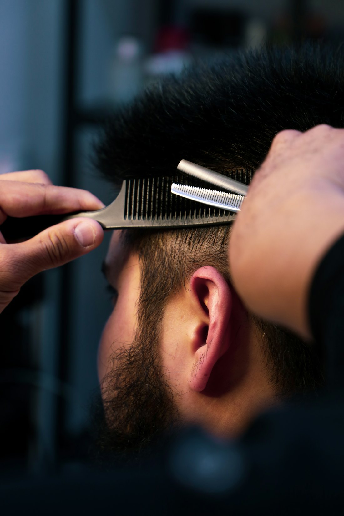 Barber cutting with scissors and comb