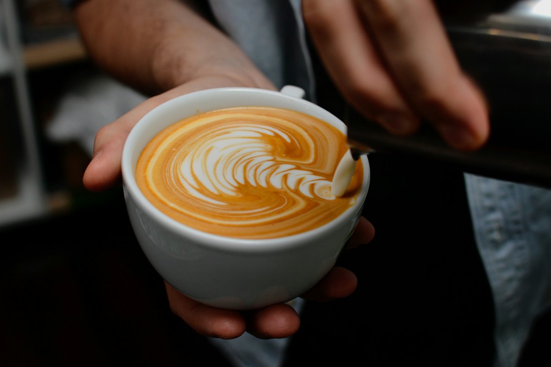 Barista serving a latte with latte art
