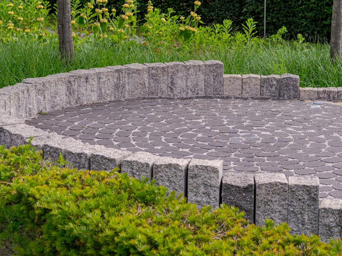 Garden with a circular stone patio after the project
